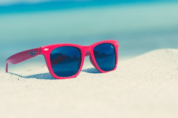 guide to make a packing Red sunglasses on a sunny beach